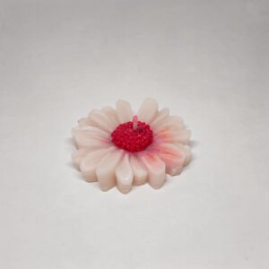 Bright pink and white daisy shaped scented candle.