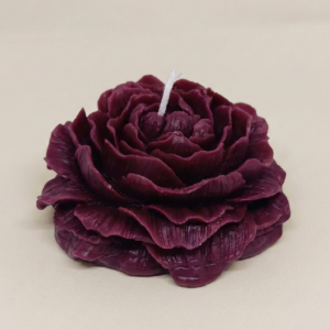 Dark burgundy rose shaped sculpted candle with layered petals.