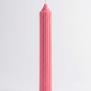A tall, hot pink, ribbed cylinder candle by Lunis Candles standing upright against a clean white background.