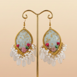 A pair of gold framed teardrop earrings featuring pastel floral resin art with gold flakes, finished with pearl and teardrop bead danglers.